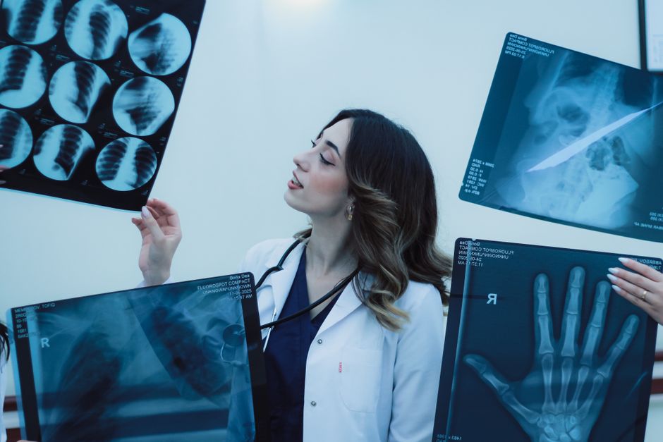 Clinician reviewing large-format medical imaging film in a clinical setting