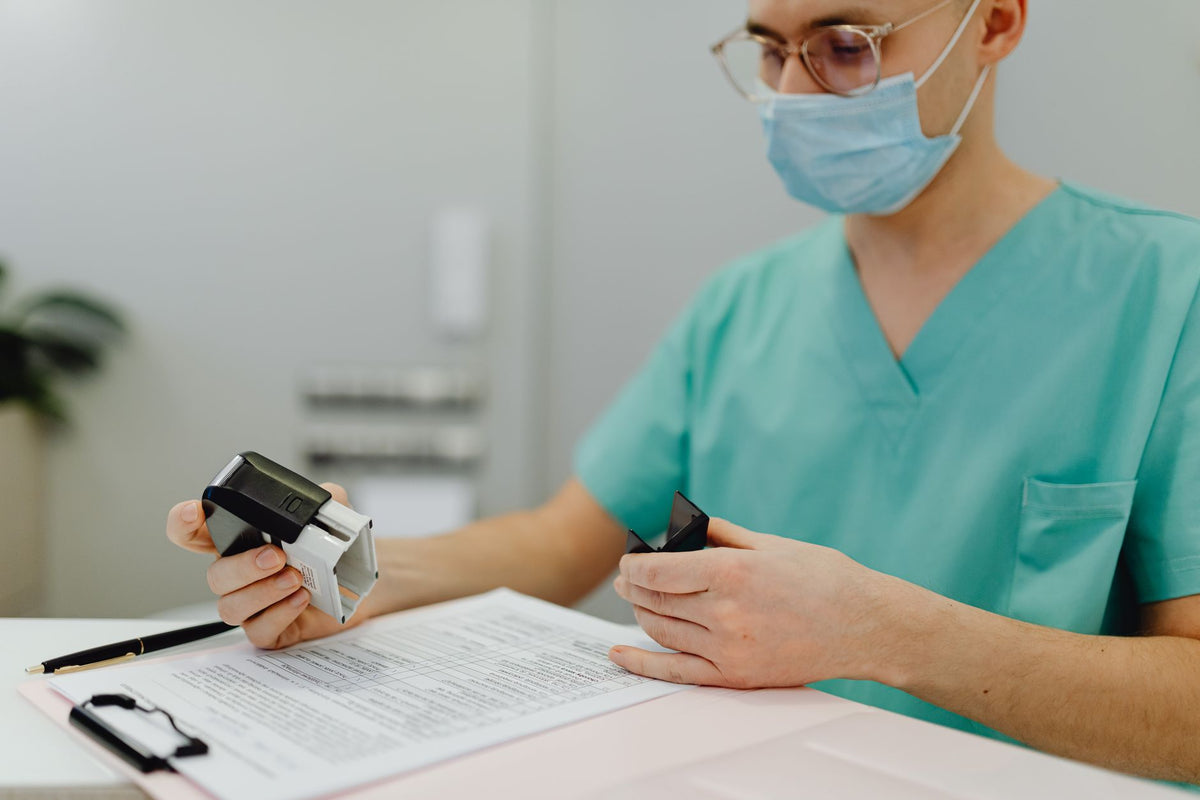 Healthcare worker reviewing supplier certification and compliance documents for medical imaging consumables