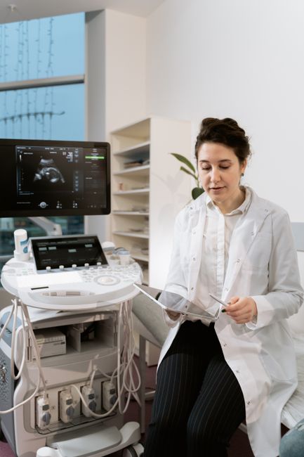 OB/GYN clinician seated beside an ultrasound machine during a fertility monitoring exam