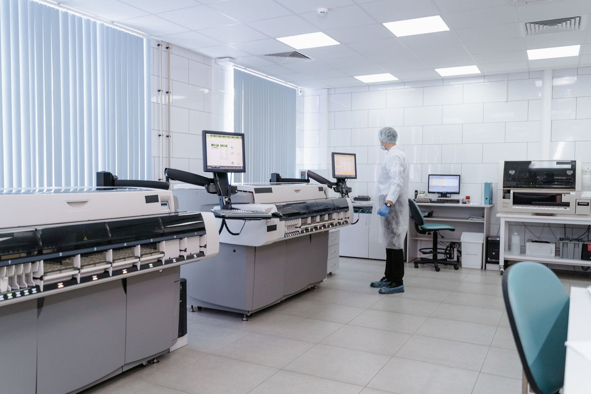 Technician analyzing data on monitors in a modern medical laboratory